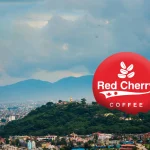 Red Cherry Coffee logo with a scenic view of Kathmandu and the surrounding hills in the background.