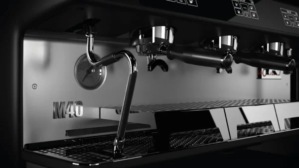 Close-up view of the La Cimbali M40 espresso machine, highlighting its ergonomic design and polished steel finish.